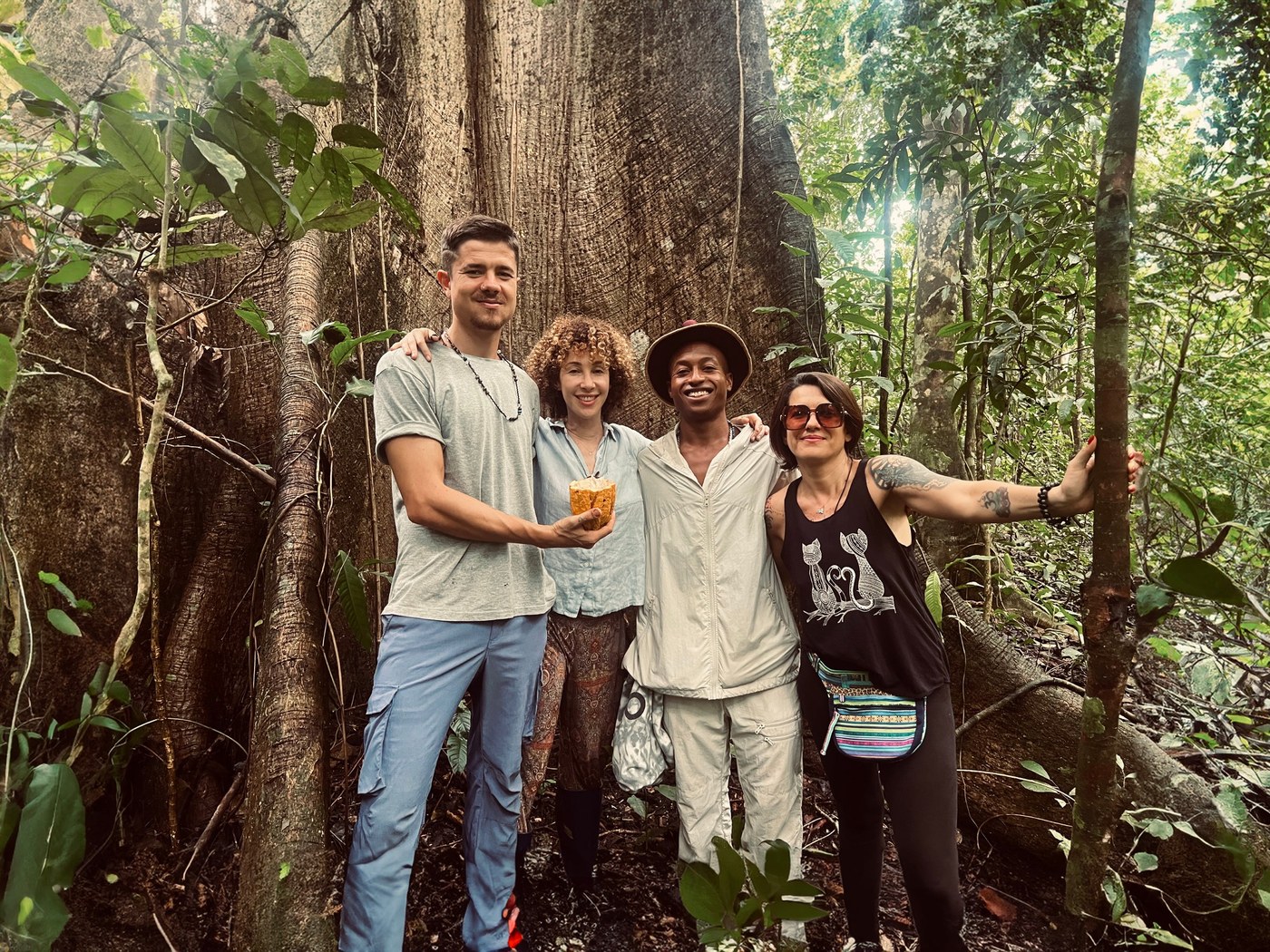 A small group at the base of a giant ceiba tree in the old-growth rainforest